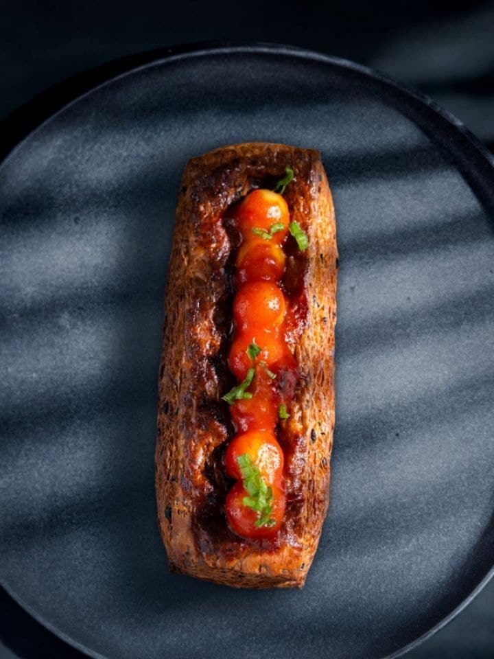 A tomato-topped bread loaf on a baking tray